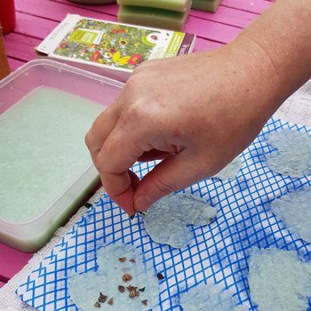Sprinkling seeds on homemade paper shapes