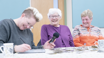 Three women sat at a table laughing